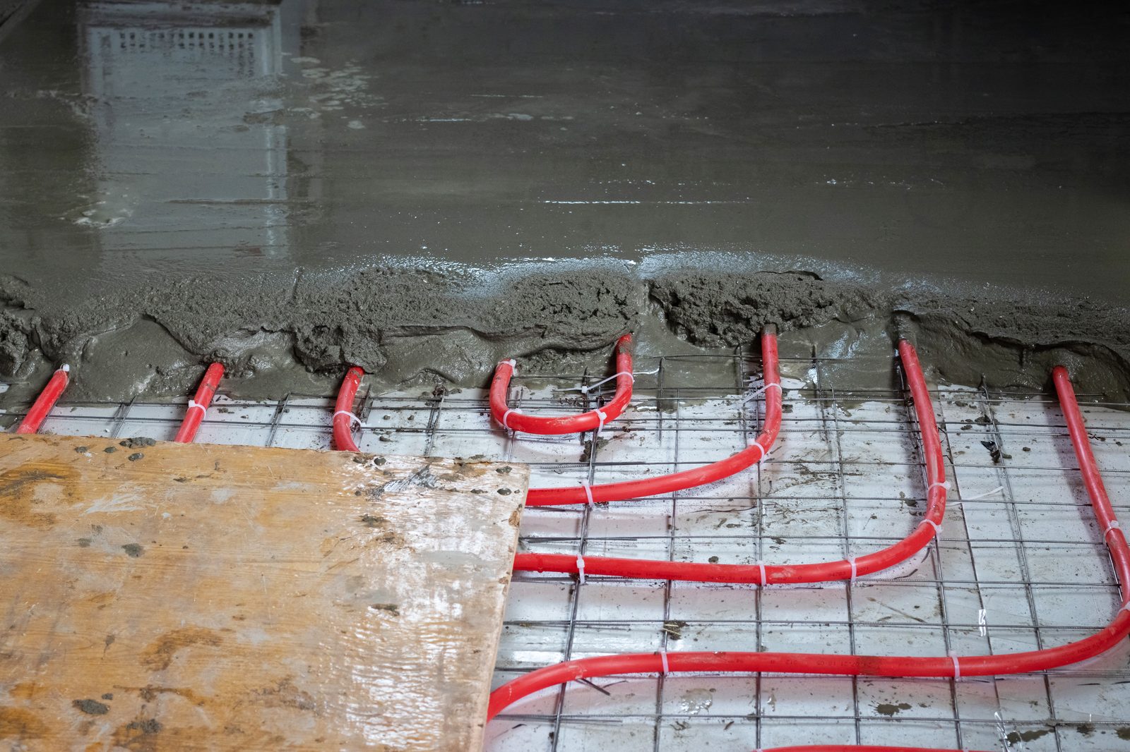 Nedlægning af gulvvarmeslanger i et eksisterende hus under renovering.